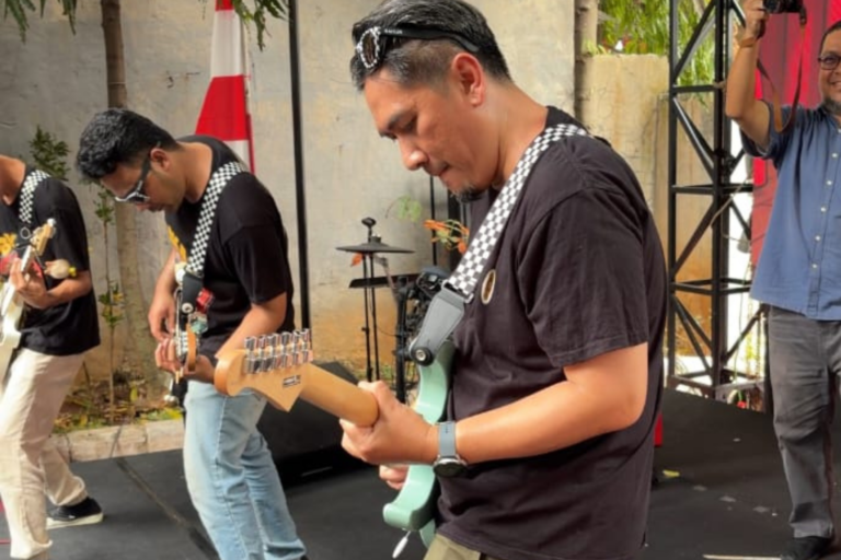 Gitaris band tampil di panggung rigging acara 17 Agustusan kantor