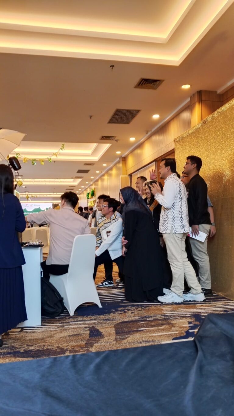 Tamu berfoto di photo booth backdrop glitter emas acara halalbihalal perusahaan
